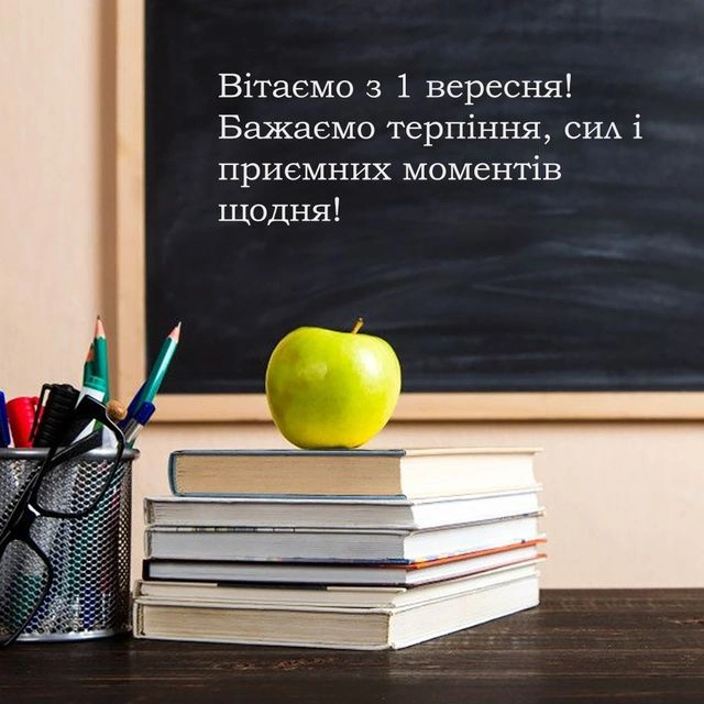 Зелене яблуко на книгах перед дошкою з привітанням.