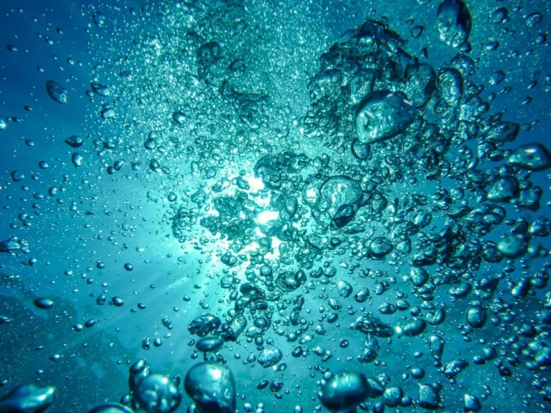 Повітряні бульбашки підіймаються в чисту воду.
