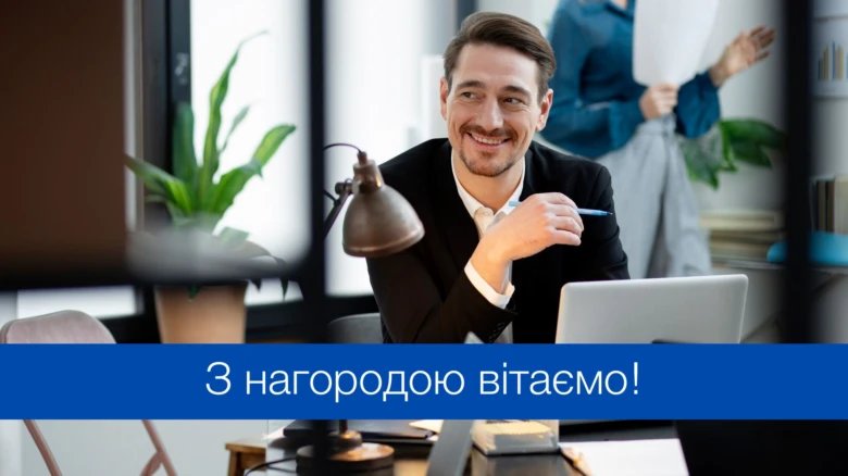 Чоловік у офісі з ноутбуком та написом про нагороду українською.