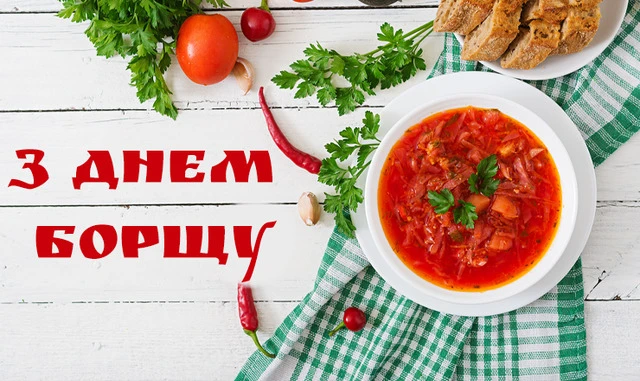 Миска борщу з овочами та хлібом на дерев'яному столі