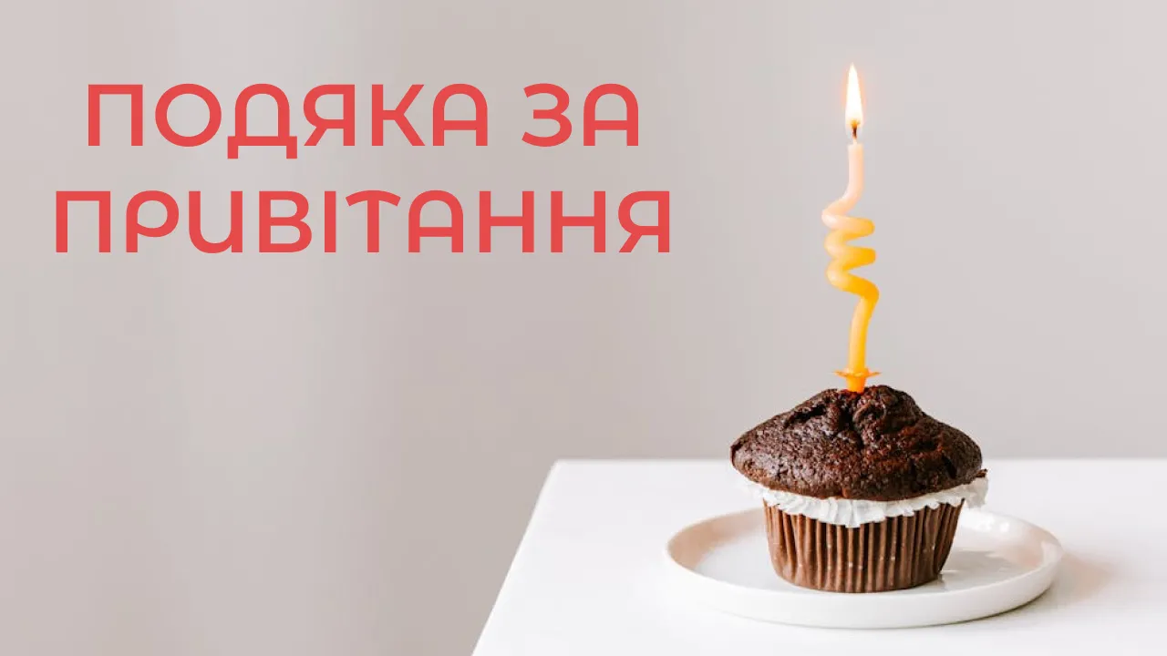 Шоколадний кекс із запаленою свічкою та українським привітанням.